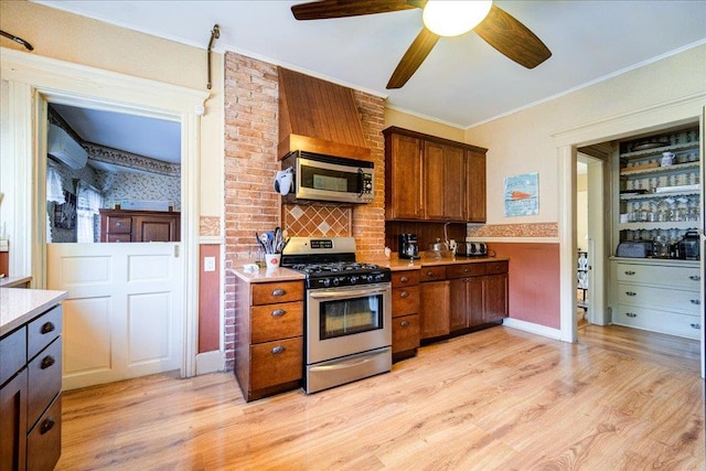 kitchen featuring ceiling fan, light hardwood / wood-style floors, ornamental molding, and stainless steel appliances