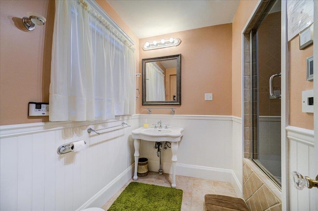 bathroom featuring sink, tile patterned floors, and enclosed tub / shower combo