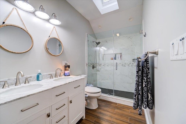 bathroom with vanity, lofted ceiling with skylight, toilet, walk in shower, and wood-type flooring