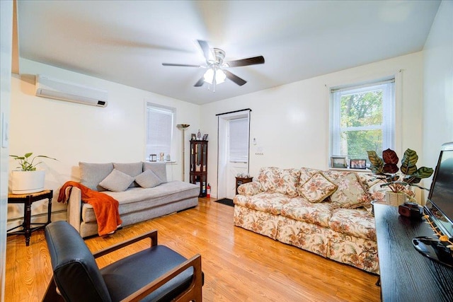 living room featuring ceiling fan, light hardwood / wood-style floors, a wall unit AC, and a baseboard heating unit