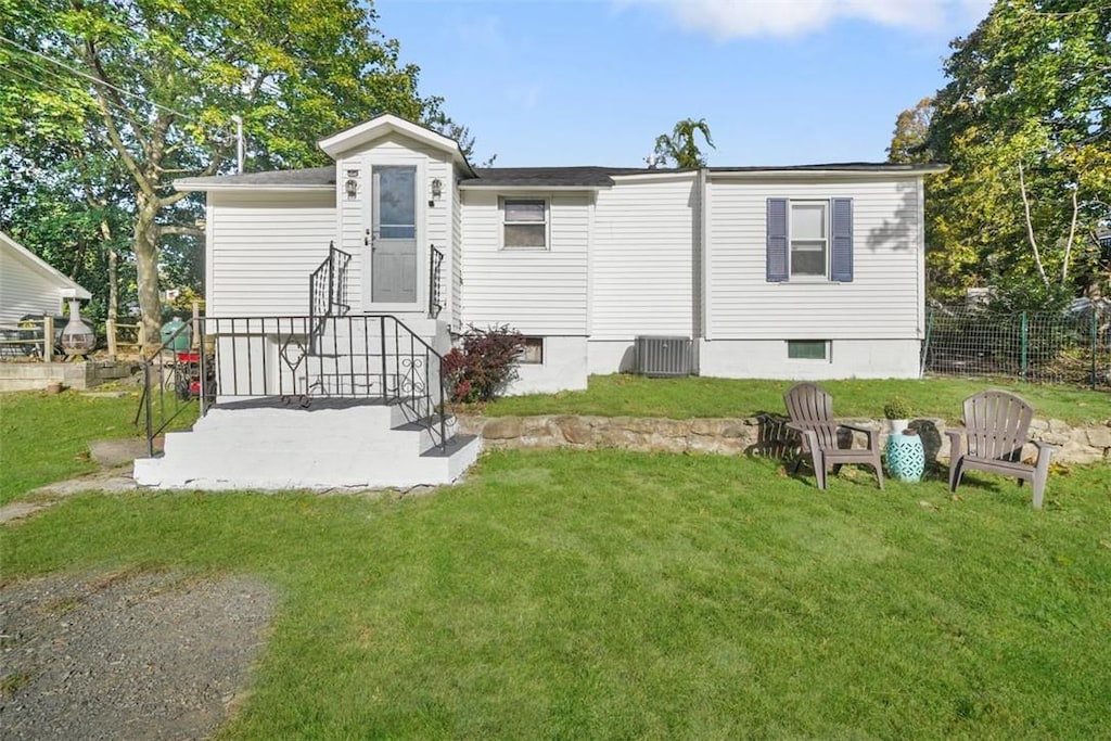 rear view of house with a lawn and central AC