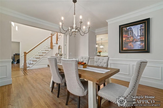 dining area featuring a notable chandelier, light hardwood / wood-style floors, and ornamental molding