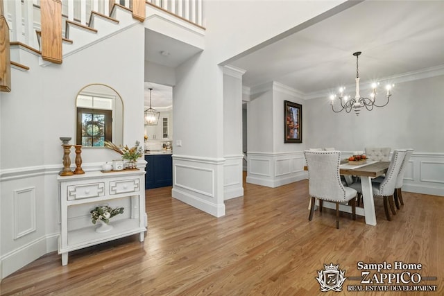 dining space featuring a chandelier, wood-type flooring, and ornamental molding