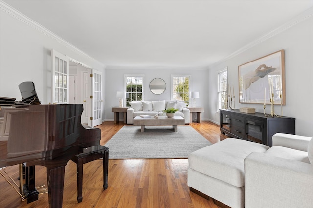 living room featuring light wood-type flooring, baseboards, and ornamental molding