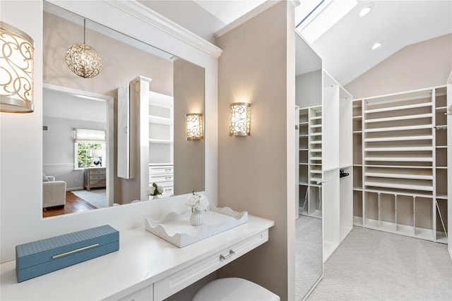 bathroom featuring lofted ceiling and a spacious closet