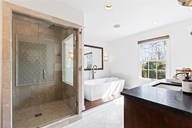 full bathroom featuring a stall shower, a freestanding bath, vanity, and tile patterned floors