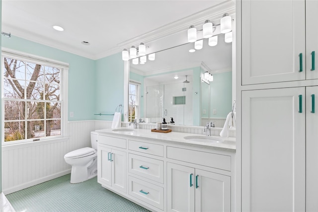 full bathroom featuring double vanity, a shower stall, a sink, and wainscoting