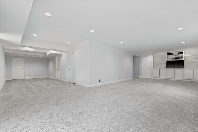 unfurnished living room featuring recessed lighting, light carpet, and baseboards