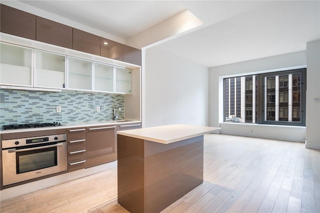 kitchen with a center island, stainless steel appliances, light hardwood / wood-style flooring, and sink