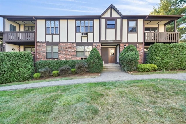 view of front of house featuring a balcony and a front yard