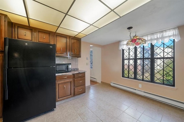 kitchen with baseboard heating, backsplash, light tile patterned floors, and black appliances