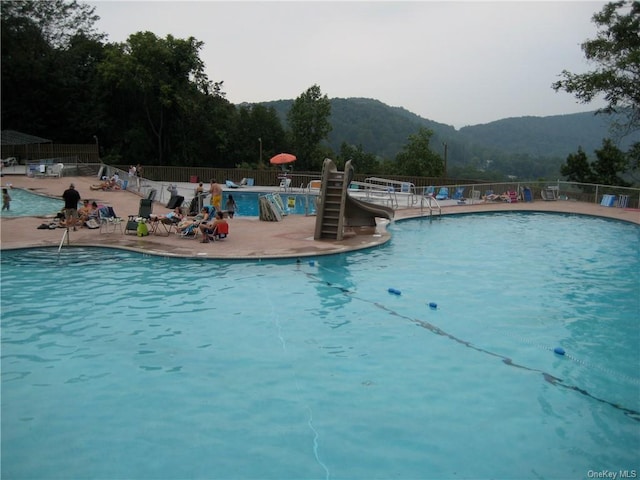 view of swimming pool featuring a mountain view and a patio