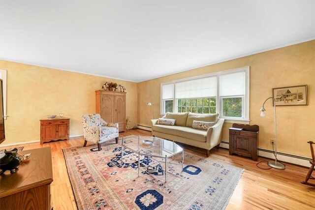 living room with baseboard heating and light hardwood / wood-style flooring