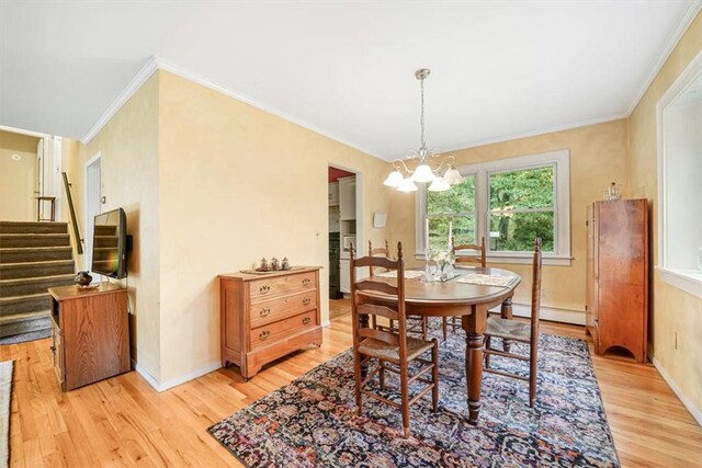 dining room with light hardwood / wood-style flooring, baseboard heating, and ornamental molding