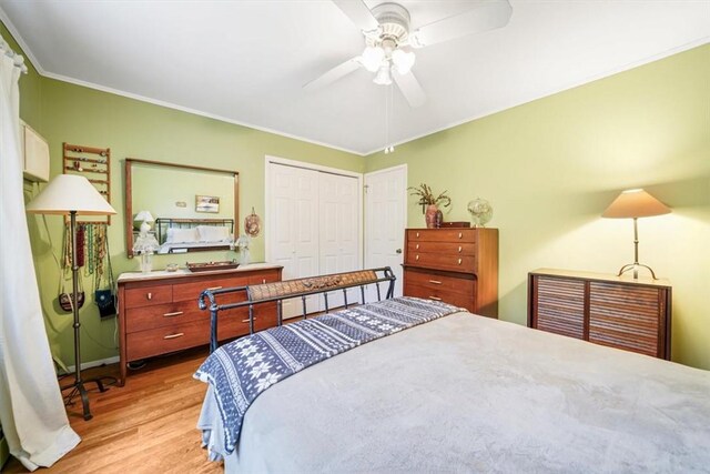 bedroom with a closet, ceiling fan, light hardwood / wood-style flooring, and crown molding