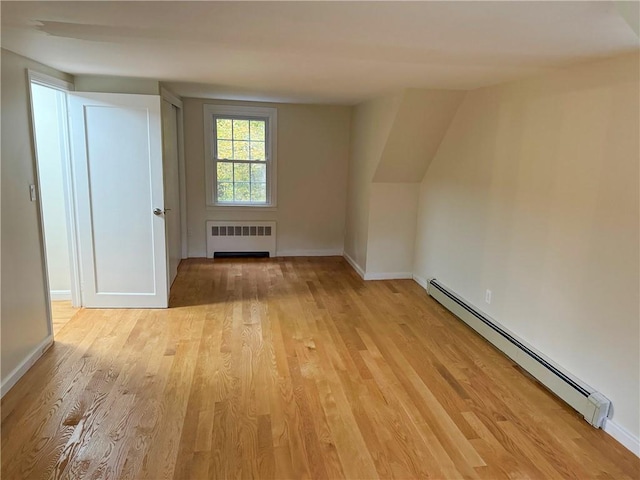 interior space featuring light wood-type flooring, radiator heating unit, and a baseboard heating unit