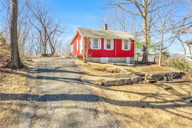 view of front of house with driveway and a chimney