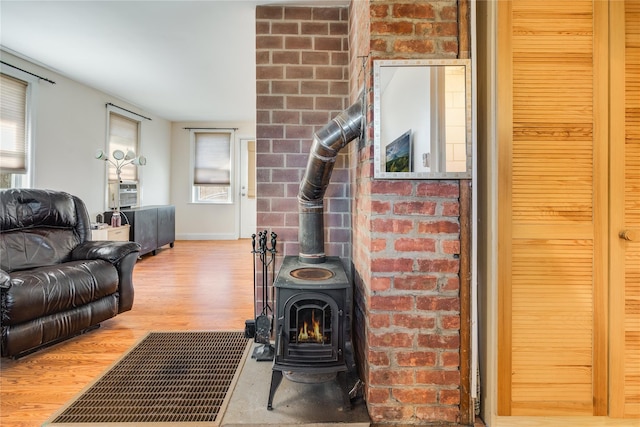 living area with a wood stove and wood finished floors