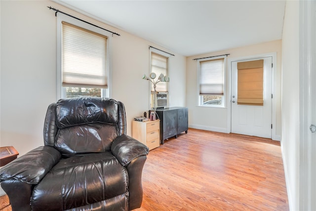 living area featuring light wood-style floors and baseboards