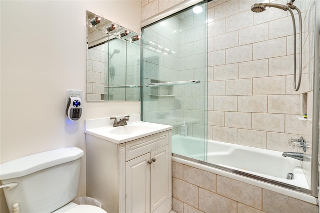 bathroom featuring vanity, toilet, and tiled shower / bath