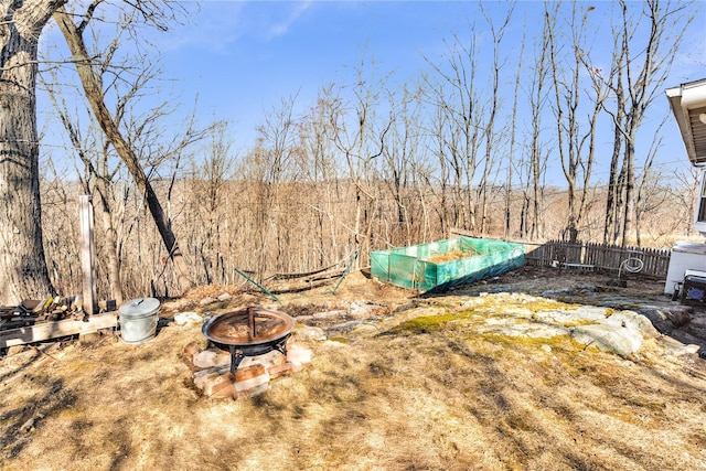 view of yard with fence and an outdoor fire pit