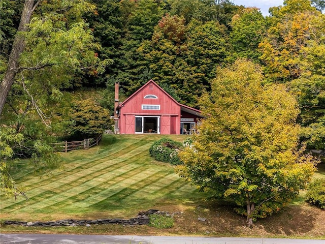 view of outbuilding featuring a rural view and a yard