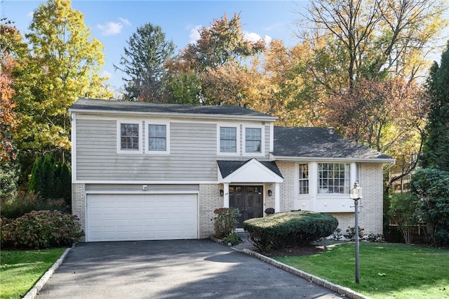 view of front of home with a front lawn and a garage