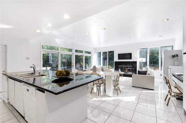 kitchen featuring white cabinetry, dishwasher, sink, a center island with sink, and light tile patterned floors