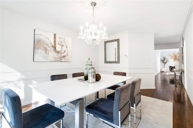 dining space featuring dark hardwood / wood-style flooring, crown molding, and a chandelier