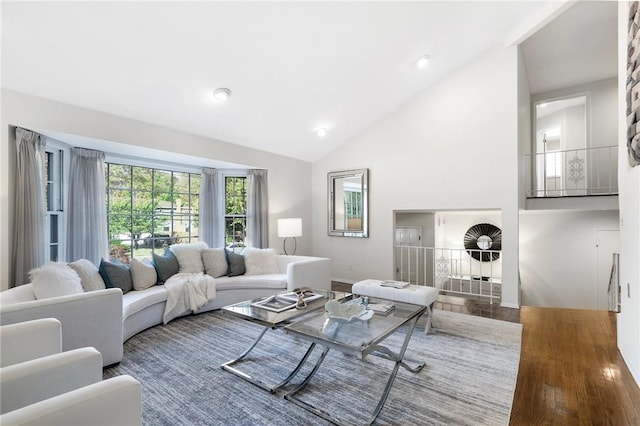 living room with hardwood / wood-style floors and high vaulted ceiling