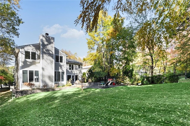 back of property featuring a patio and a lawn