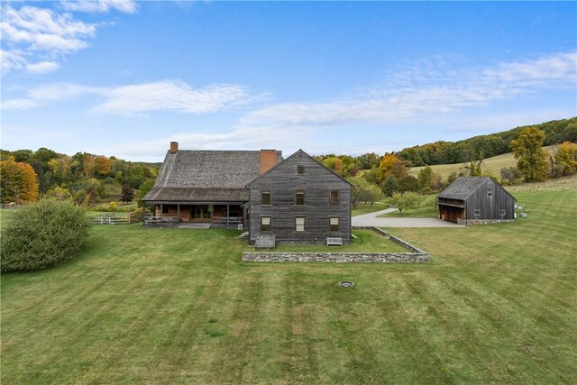 back of property featuring an outbuilding and a yard