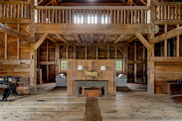 misc room featuring wood-type flooring and a towering ceiling