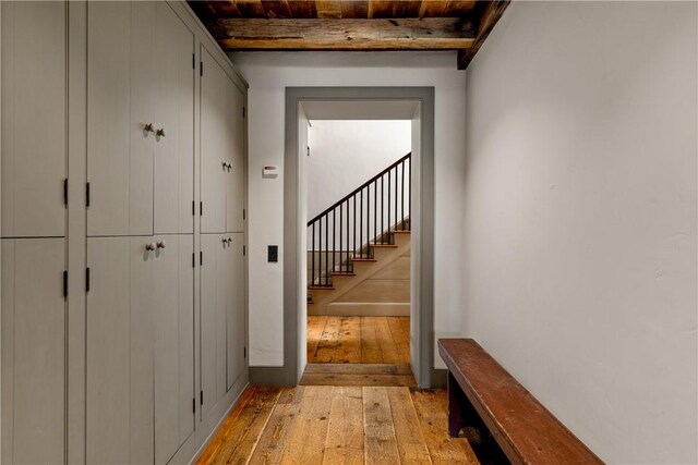interior space featuring beamed ceiling, wood ceiling, and light wood-type flooring