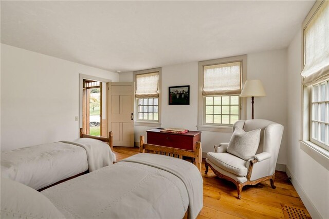 bedroom with light hardwood / wood-style flooring and multiple windows