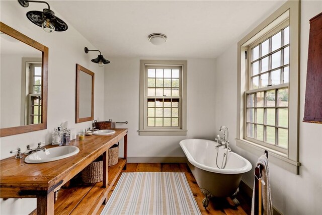 bathroom featuring hardwood / wood-style flooring, vanity, and a tub