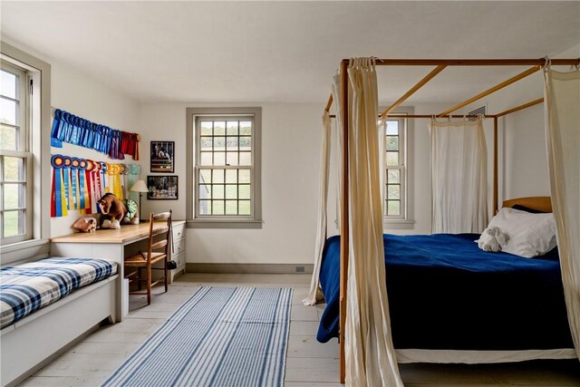 bedroom with light wood-type flooring and multiple windows