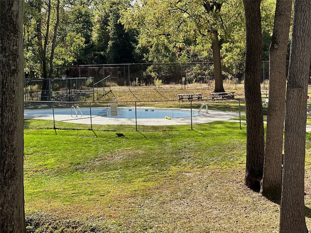 view of swimming pool featuring tennis court and a lawn