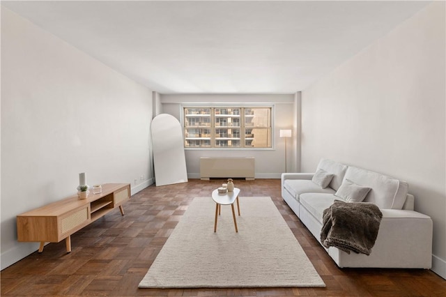 living room with radiator heating unit and dark parquet floors