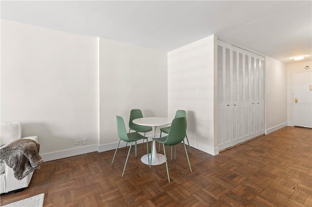 dining area featuring dark parquet floors