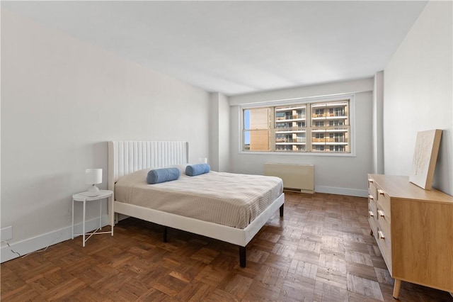 bedroom featuring radiator and dark parquet flooring