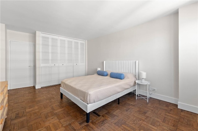 bedroom with dark parquet flooring and a closet