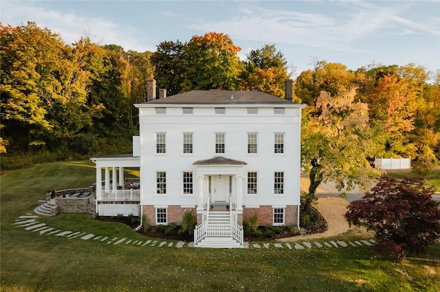 colonial house featuring a front lawn