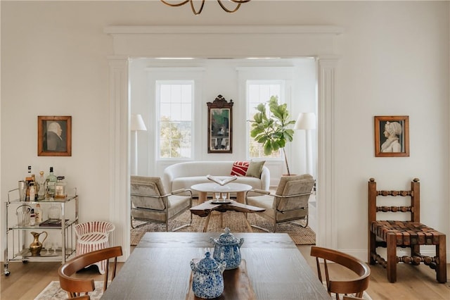 living area with an inviting chandelier and light hardwood / wood-style flooring