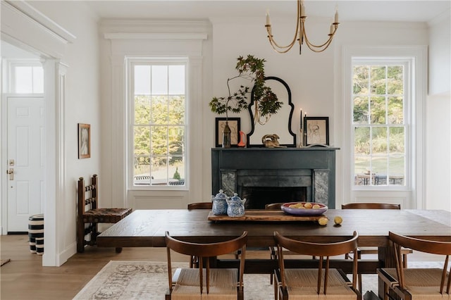 sitting room with an inviting chandelier, wood-type flooring, and ornamental molding