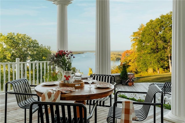 sunroom / solarium with a water view and ornate columns