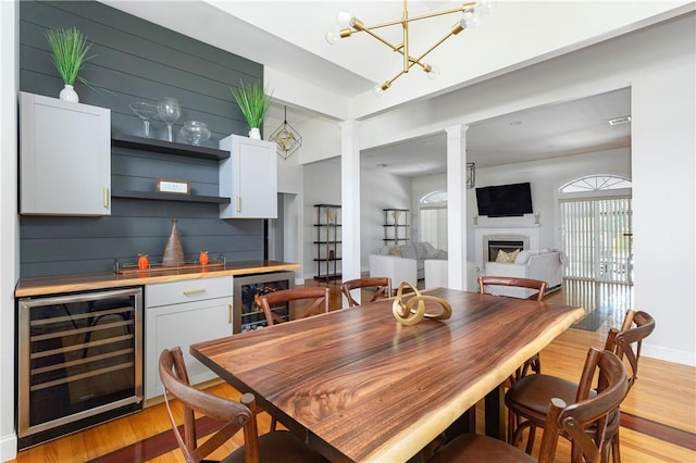 dining room featuring light hardwood / wood-style floors, beverage cooler, and bar area