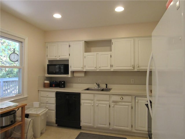 kitchen featuring black appliances, white cabinetry, and sink