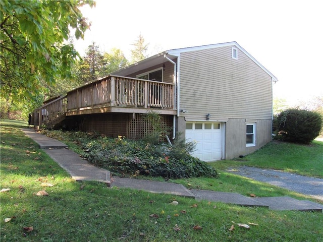 view of home's exterior with a lawn, a garage, and a deck