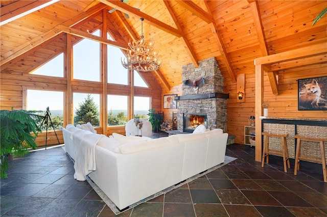 living room featuring wooden walls, high vaulted ceiling, and a healthy amount of sunlight